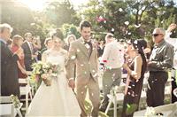 Petals being thrown as couple walk down the aisle